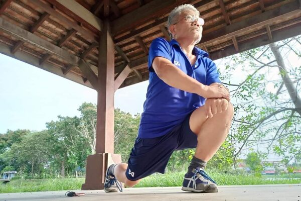 elderly man stretches outdoors